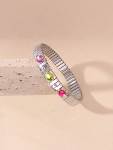 Detail of stretch bracelet featuring three oval faceted acrylic gems in gold settings