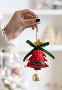 Detail of a red felt Christmas tree ornament with a golden bell and Merry Christmas ribbon