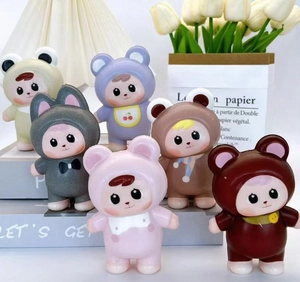 Group of cute miniature dolls in colorful animal costumes displayed on a book