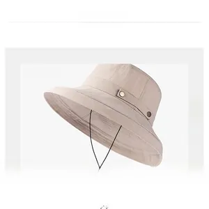 Détail d'un chapeau de soleil kaki à large bord avec bande de tissu et boucle en métal