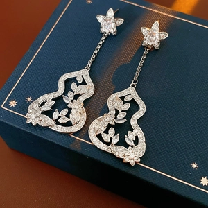 Detailed macro shot of silver flower earrings featuring hollow leaves and zircon stones