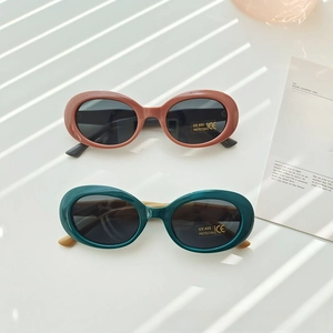 Detail of oval kids sunglasses with UV400 protection lenses and terracotta frames