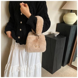 Close-up of khaki faux fur bucket bag with plush handle and small metal plate detail