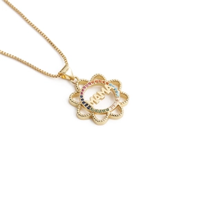 Detail of gold MAMA pendant with rainbow zircon stones and heart flower disk
