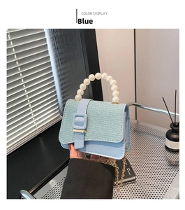 Detailed macro of a light blue tweed mini bag with pearl handle and golden chain