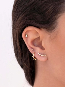 Close-up of gold geometric earring set featuring round studs and zircon ear cuffs