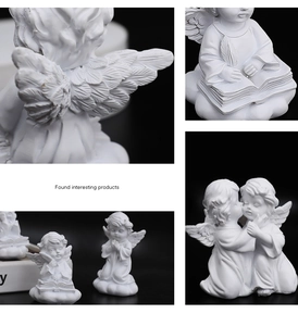 Detail of white resin angel statues showing delicate wing feathers and praying poses