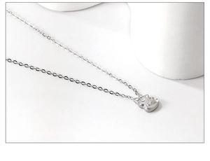 Gros plan d'un pendentif dinosaure en argent orné de petites pierres précieuses