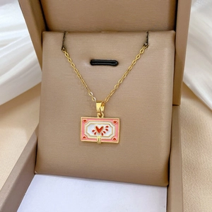Close-up of gold titanium necklace with a pink rectangular heart pendant in a gift box