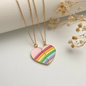 Detail of interlocking gold heart pendant with pink and rainbow enamel for friends