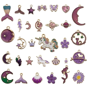 Purple and gold enamel charms collection featuring mermaid tails, stars, and moon shapes