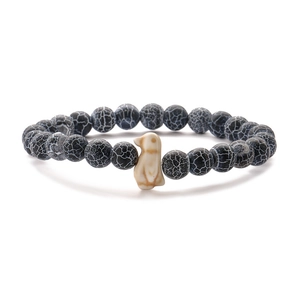 Elastic beaded bracelet with tiger eye stones and a white penguin-shaped animal bead