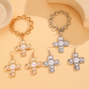 Detailed view of snail swirl texture cross jewelry set with bracelets and earrings