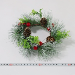 Detailansicht vom verschneiten Weihnachtskranz mit Kiefernnadeln, Beeren und Zapfen