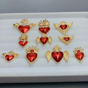 Gothic gold-plated heart wing rings with red enamel and zircons set in a display tray