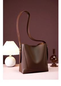 Detail der braunen Leder-Eimertasche mit feiner Textur und langem Schultergurt