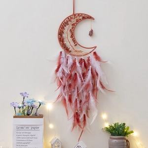 Detail of crescent moon dream catcher with tree of life crystals and pink feathers