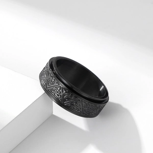 Macro view of black stainless steel spinner ring with Celtic knot engraving detail