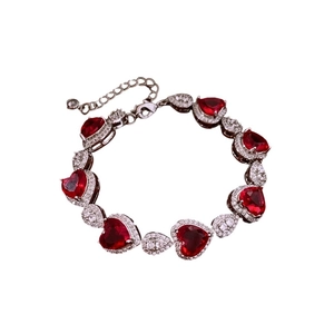 Bracciale vintage in argento con pietre rosse a cuore e zirconi bianchi su sfondo bianco