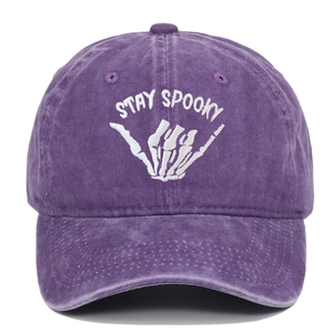 Detail of white Stay Spooky embroidery on vintage washed purple cotton baseball cap