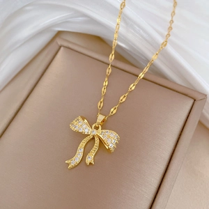 Close-up of golden bow pendant with sparkling cubic zirconia on a luxury necklace