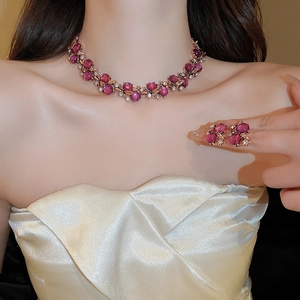 Detail of luxury flower necklace set with pink gemstones and crystals on model