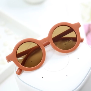 Detail of round matte orange kids sunglasses with UV400 and CE marking on the lens