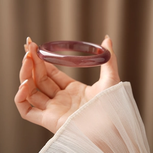 Close-up of translucent purple round cat eye stone bracelet with smooth polished finish
