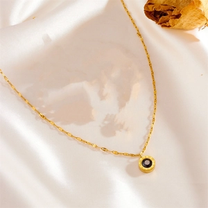 Detail of Roman numeral gold necklace with black gemstone pendant on silk