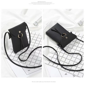 Detail of black litchi grain leather crossbody bag with gold ring buckle and flap closure