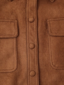 Detalle de chaqueta de ante marrón con bolsillos de solapa y botones de tela forrados