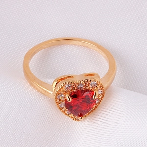 Close-up of heart-shaped ruby ring with surrounding white zircons and golden band