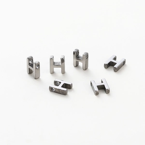 Detailed macro view of H-shaped metal beads with vacuum plating and smooth silver finish
