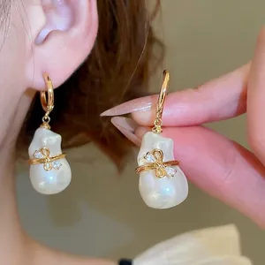 Boucles d'oreilles perles baroques avec nœud plaqué or 18 carats et zircons brillants