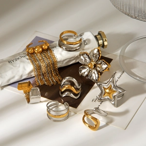 Detail view of two-tone stainless steel rings featuring star and floral designs