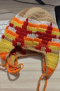 Detail of colorful hand-knitted beanie with cat ears and thick wool texture