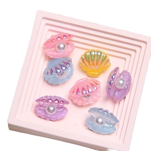 Colorful iridescent resin pearl shells for DIY crafts displayed on a pink tray