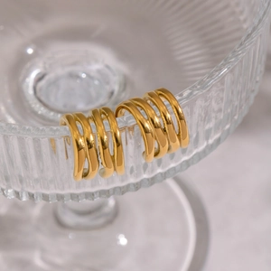 Minimalist geometric gold layered hoop earrings with irregular lines on glass