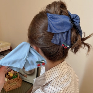 Detailed denim bow hair clip featuring cherry embroidery and white pearl accents