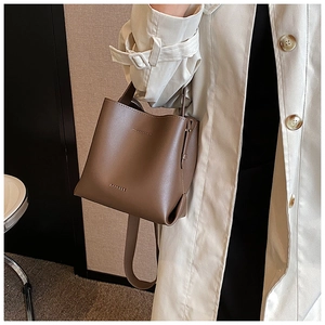 Mocha brown bucket bag details showing smooth faux leather texture and gold brand logo