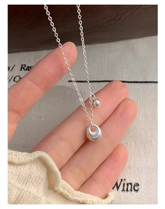 Close-up of S925 sterling silver necklace featuring irregular round pendant and small bead