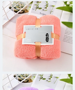 Detailed view of pink coral fleece face towel tied with ribbon in gift packaging