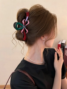 Détail d'une pince à cheveux élégante tricolore en forme de nœud sur modèle
