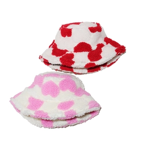 Detailed close-up of fluffy heart pattern faux fur bucket hats in red and pink colors