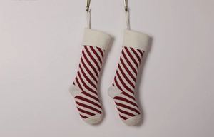 Detail of red and white striped knitted Christmas stockings with white cuffs and hanging loops