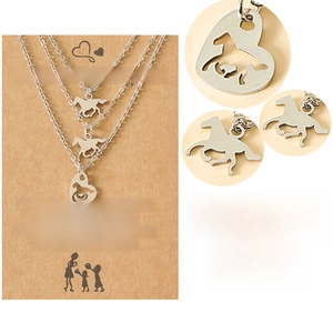 Macro view of stainless steel heart and horse pendant necklaces with Mother's Day card