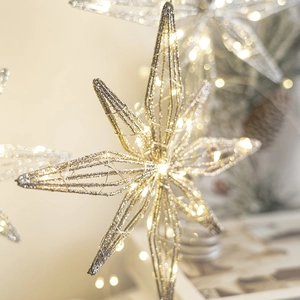 Luminous gold Christmas tree topper star with warm LED lights and intricate metal wire patterns