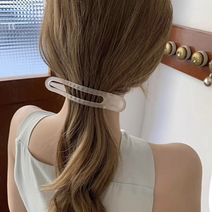 Detailed view of a frosted translucent hair clip styled on a woman's ponytail