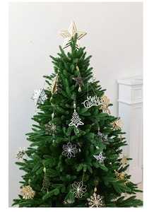 Close-up of golden Christmas star and snowflake ornaments on a festive pine tree