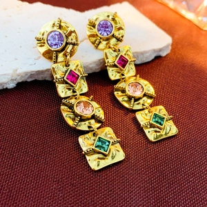 Detailed macro shot of vintage gold earrings with colorful geometric faux gemstones